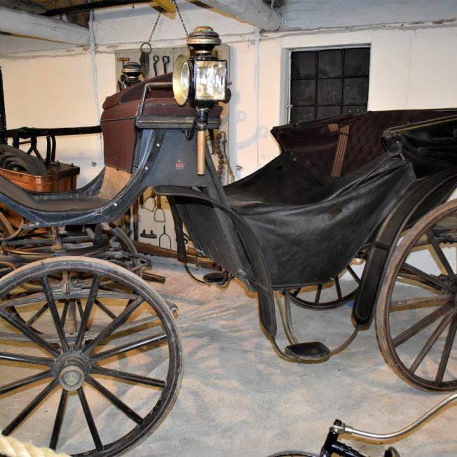Museum med gamle cykler, kareter og biler.
